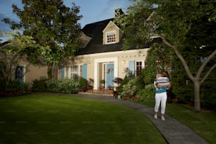 a woman standing in front of a house