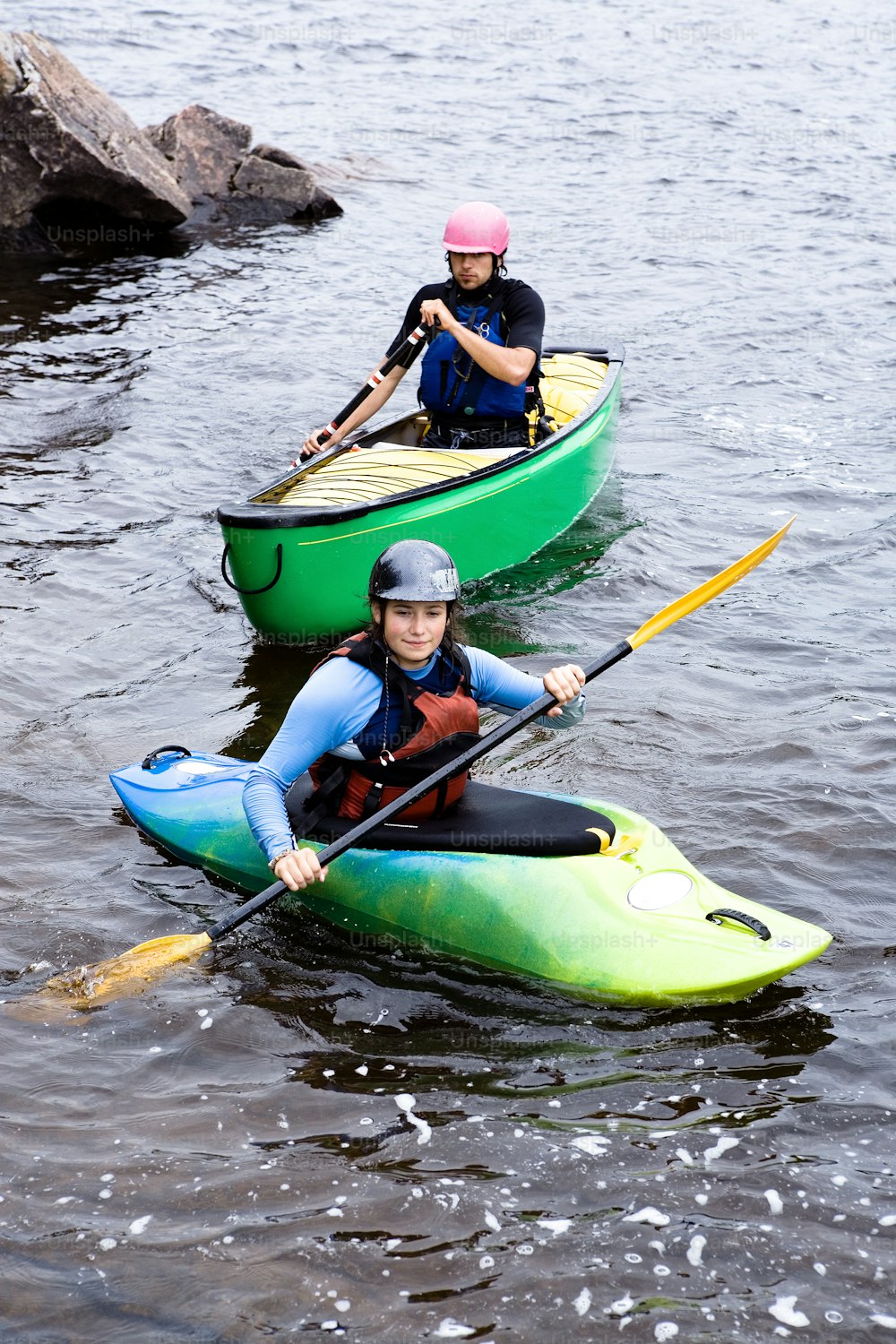 Zwei Personen in Kajaks paddeln auf dem Wasser