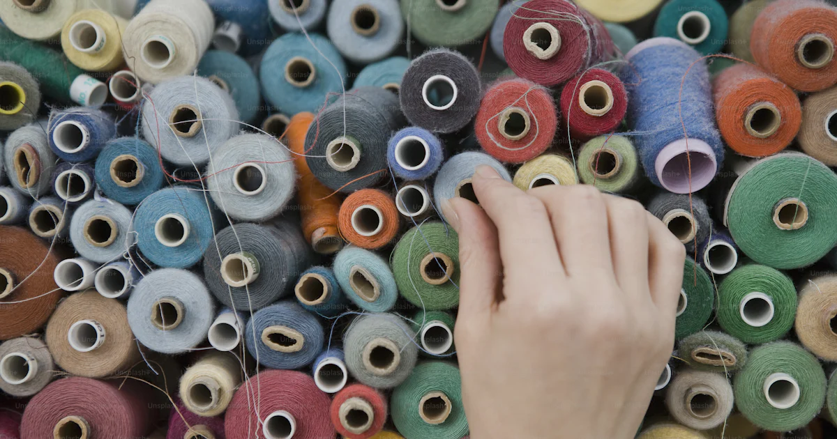 Threadd Photo A person is reaching for a spool of thread photo – Multi colored Image ...
