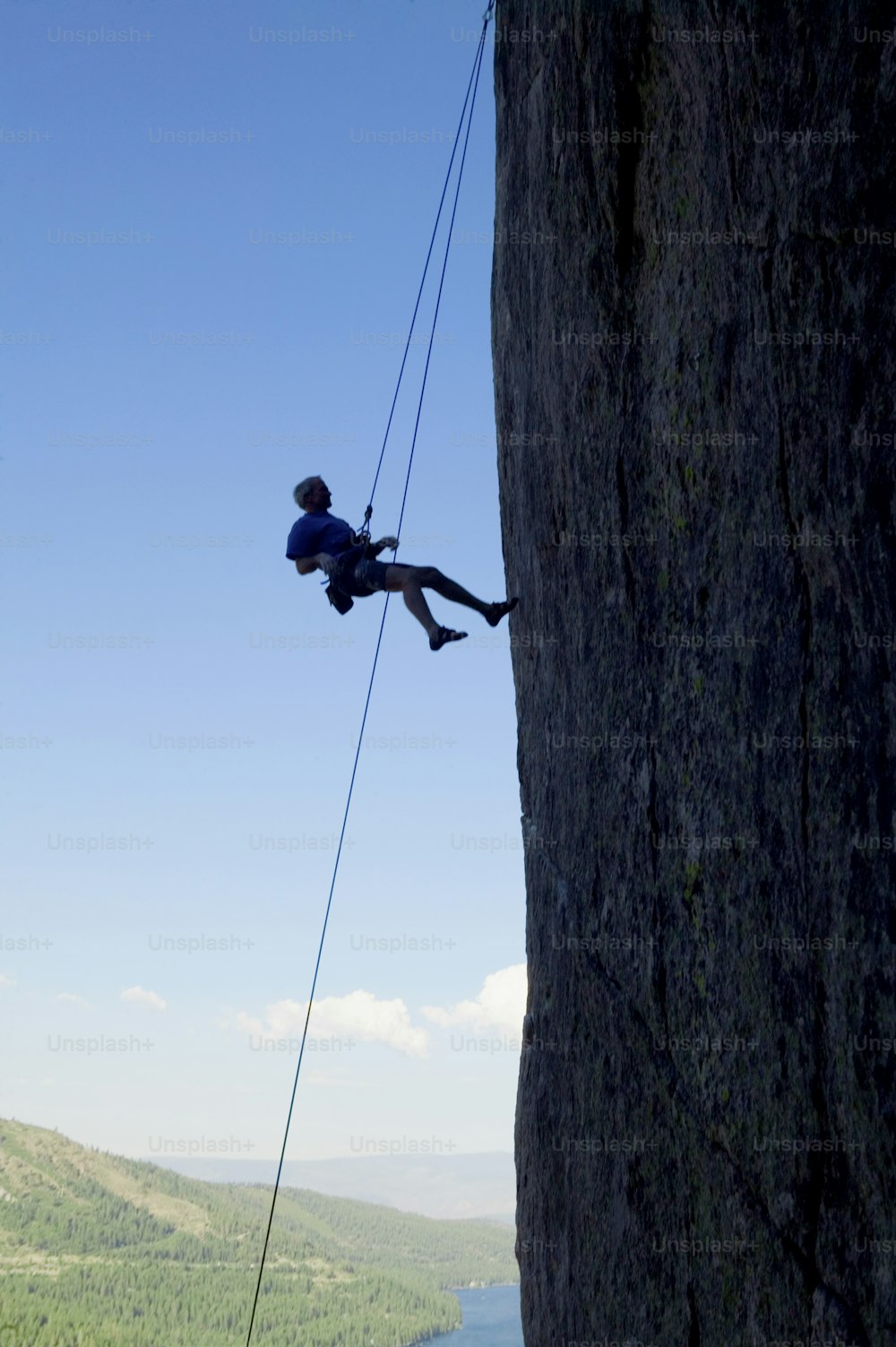 a man climbing up a cliff with a rope