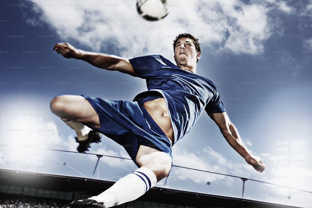 a man kicking a soccer ball on top of a field