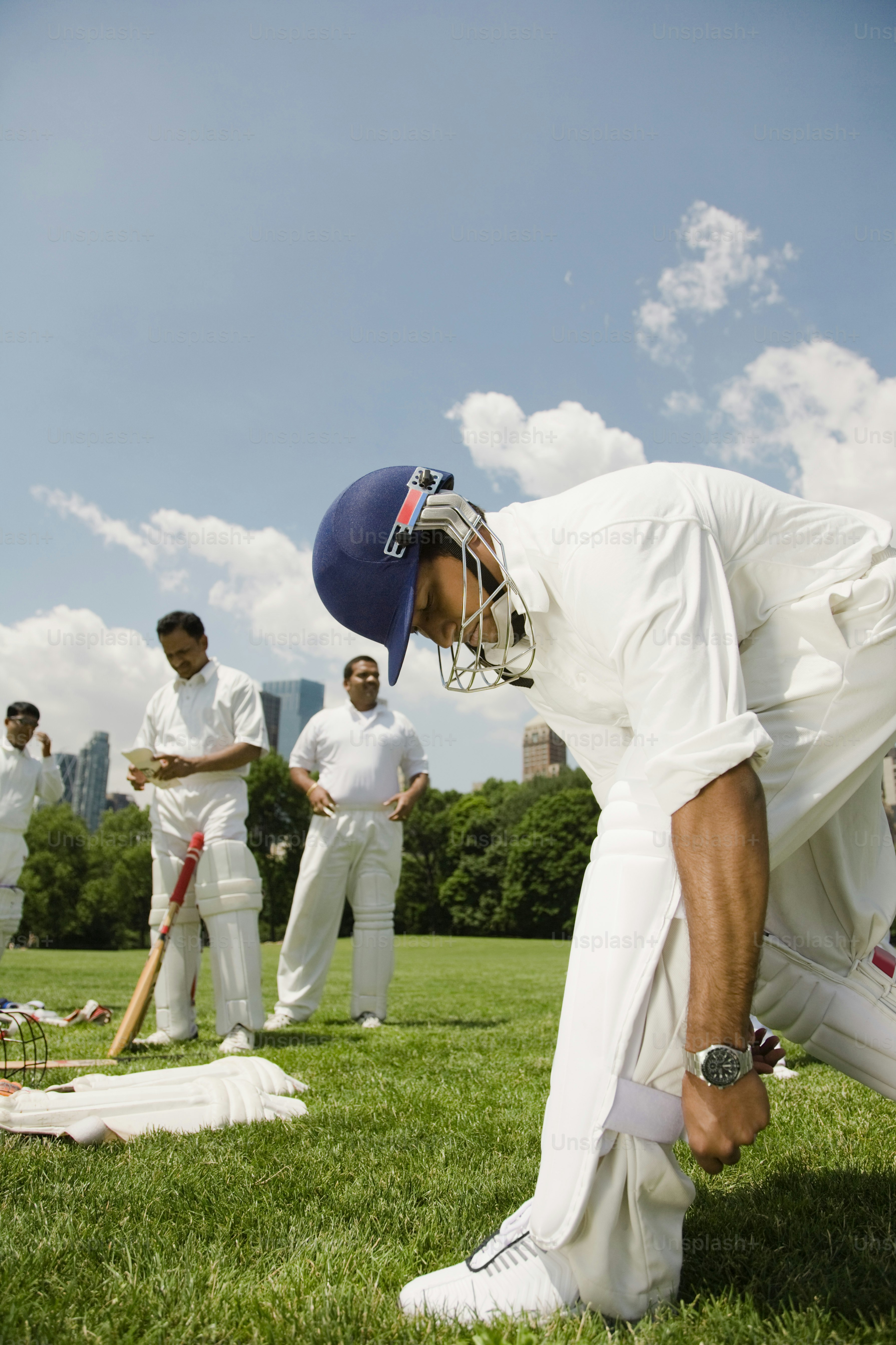 a group of men standing on top of a lush green field