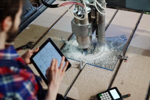 Engineer with touchpad and lathe machine