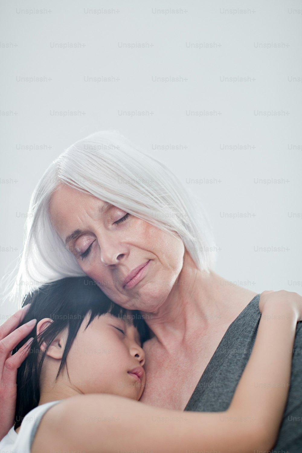 Eine ältere Frau umarmt eine jüngere Frau