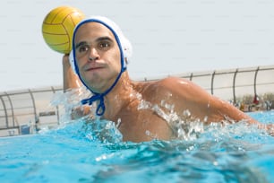 Un hombre en una piscina con una pelota en la cabeza