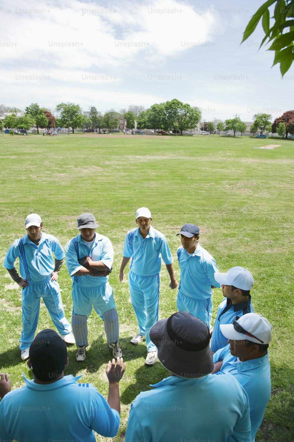 a group of men standing on top of a lush green field