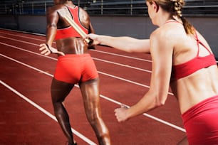 Una mujer con un sujetador deportivo rojo preparándose para correr