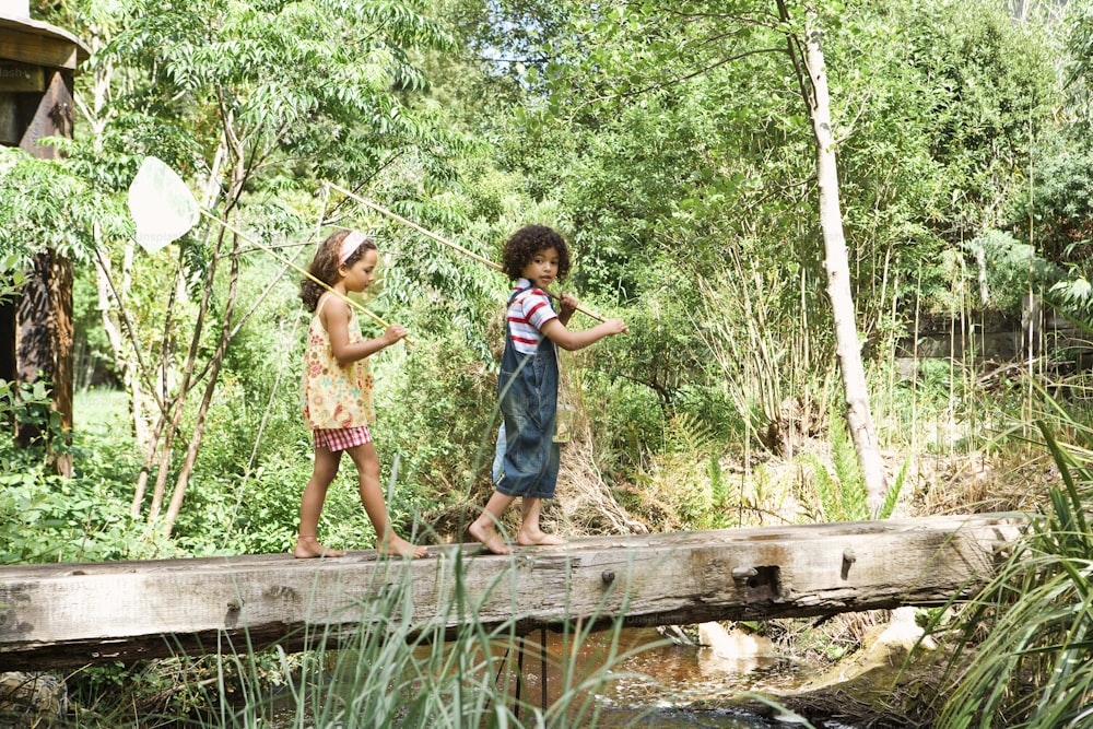 Dos niñas caminando por un puente de madera