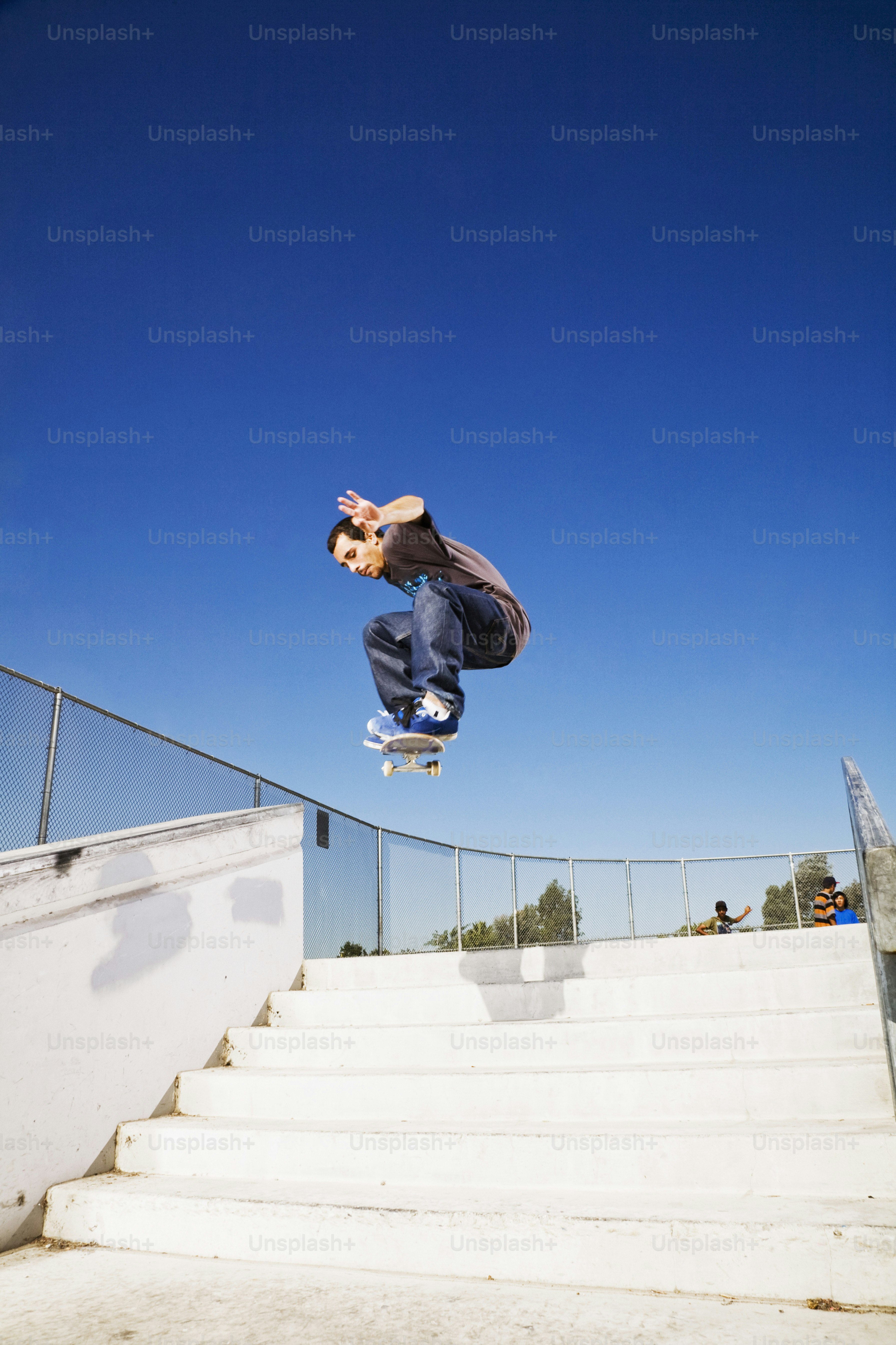 A man flying through the air while riding a skateboard photo – Riding ...
