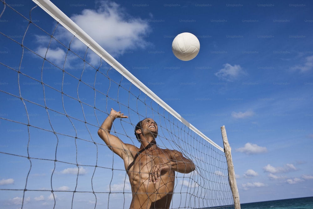 Un uomo sta giocando a pallavolo sulla spiaggia
