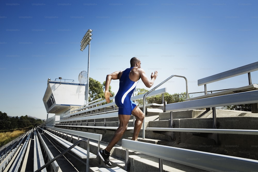 a man in a blue swimsuit is running up some stairs