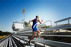 Un hombre en traje de baño azul sube corriendo unas escaleras