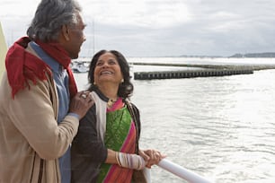 a man standing next to a woman on a boat