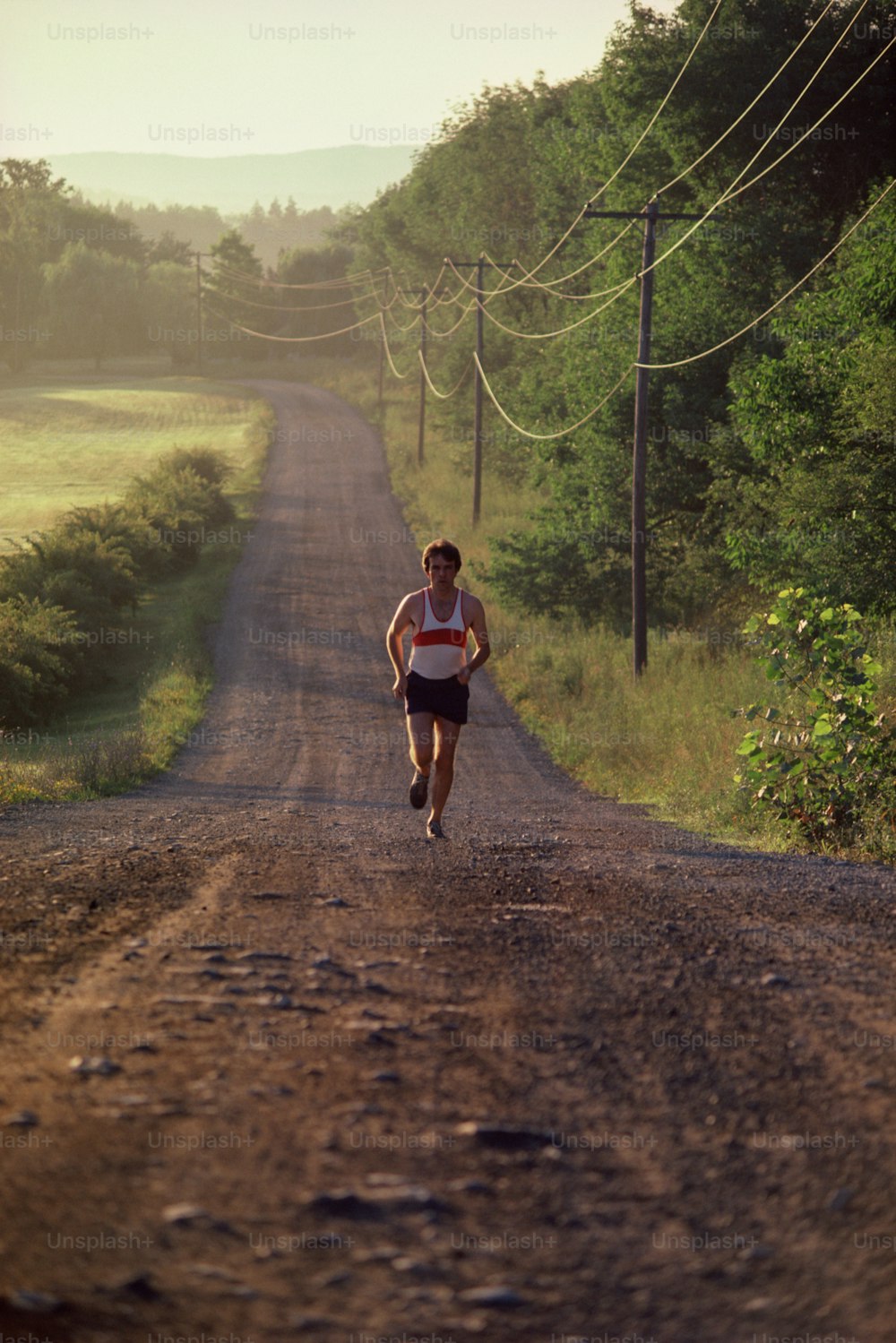 a man is running down a dirt road
