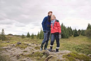 a man and a woman standing on top of a hill