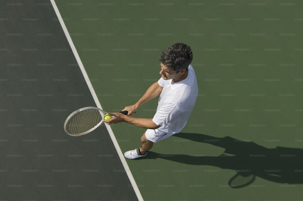 テニスコートの上にテニスラケットを持つ男性