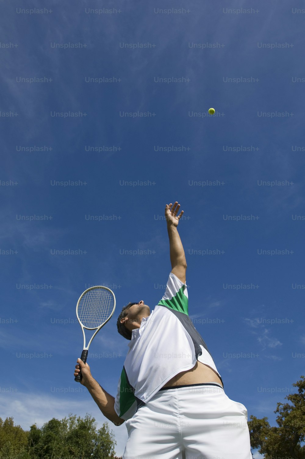 Ein Mann, der einen Tennisschläger auf einem Tennisplatz hält