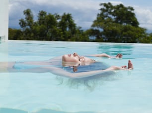 Una mujer flotando en una piscina con los pies en el agua
