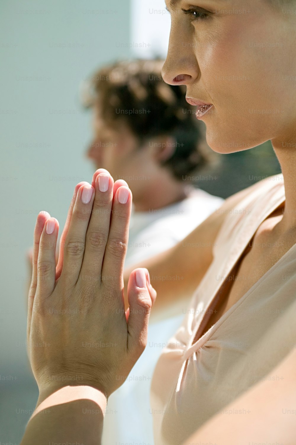 uma mulher com as mãos cruzadas em oração