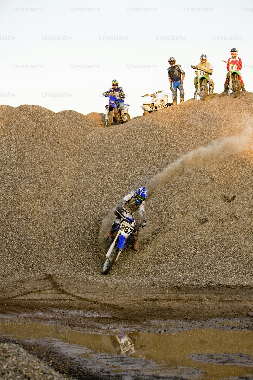 a man riding a dirt bike on top of a dirt hill