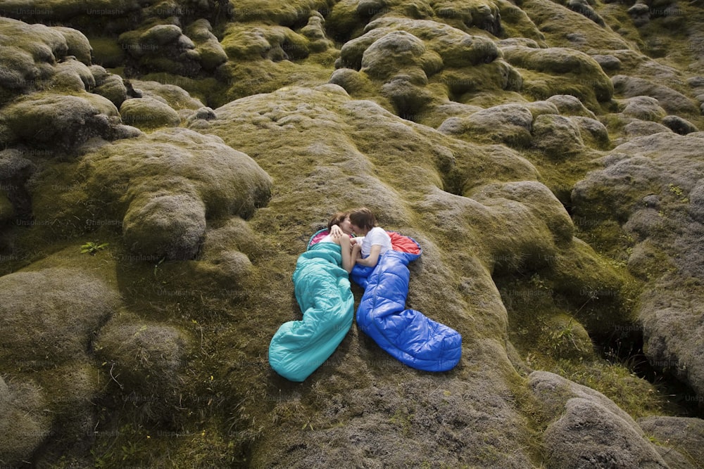 uma pessoa deitada em uma rocha coberta de musgo