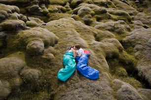 a person laying on a rock covered in moss
