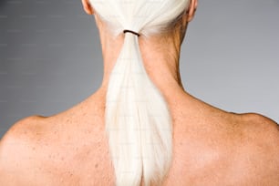 la parte posterior de la cabeza de una mujer con cabello largo y blanco