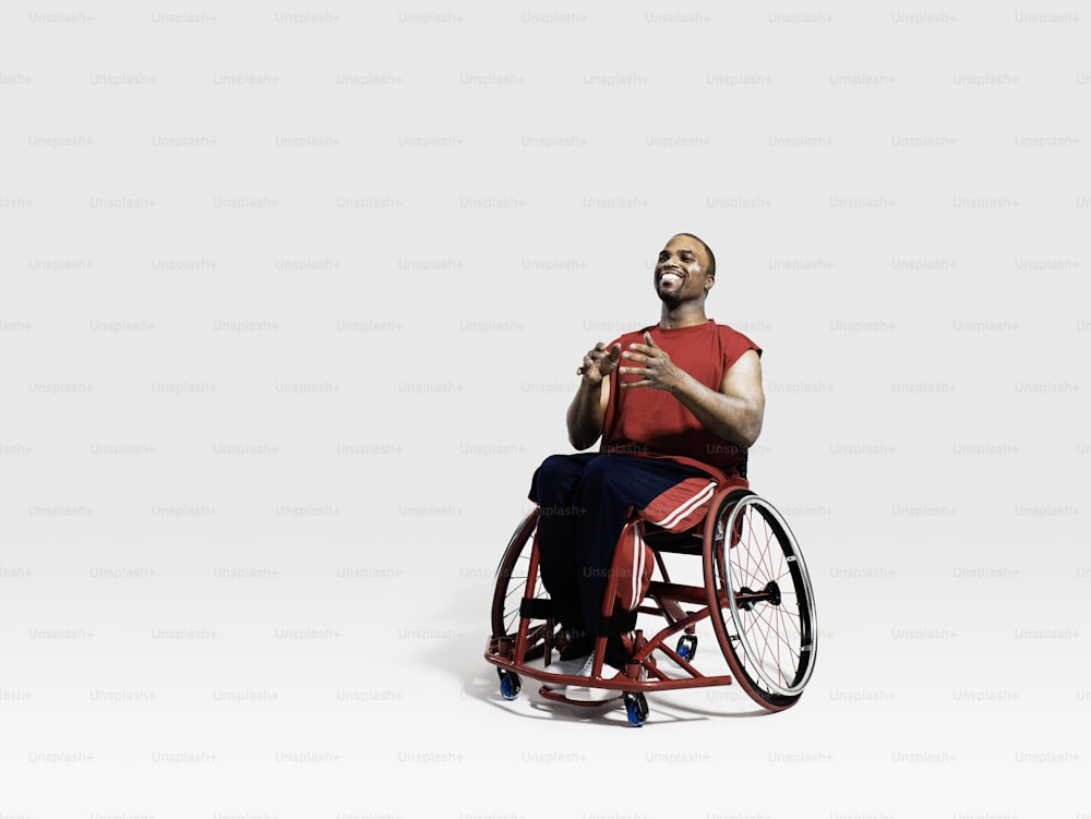 um homem em uma cadeira de rodas com as mãos juntas