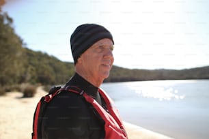 Un uomo in piedi su una spiaggia accanto a uno specchio d'acqua