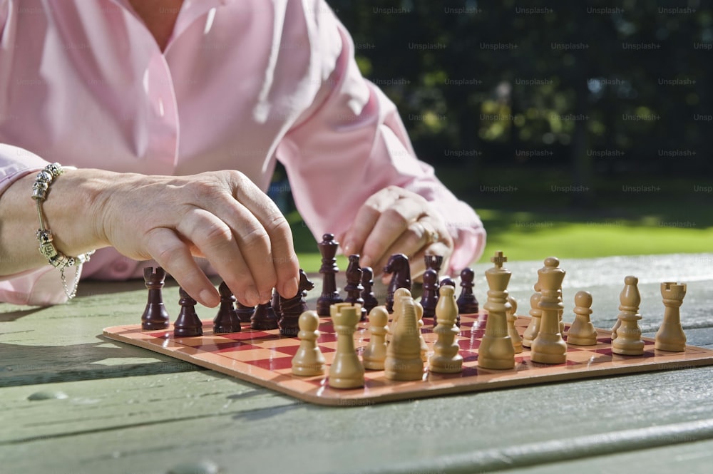 una persona jugando una partida de ajedrez sobre una mesa