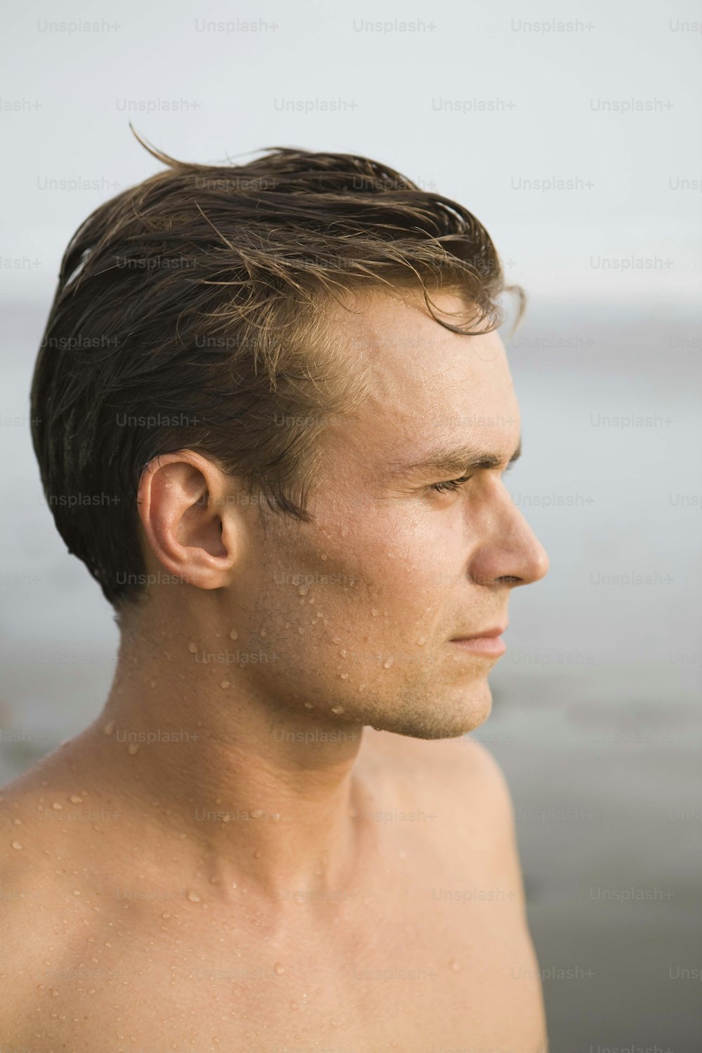 Un uomo con i capelli bagnati in piedi nell'acqua