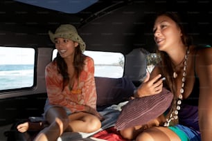Deux jeunes femmes assises à l’arrière d’une camionnette