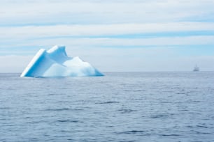 an iceberg floating in the middle of the ocean