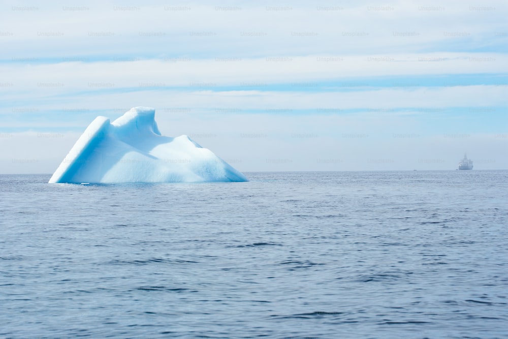 an iceberg floating in the middle of the ocean