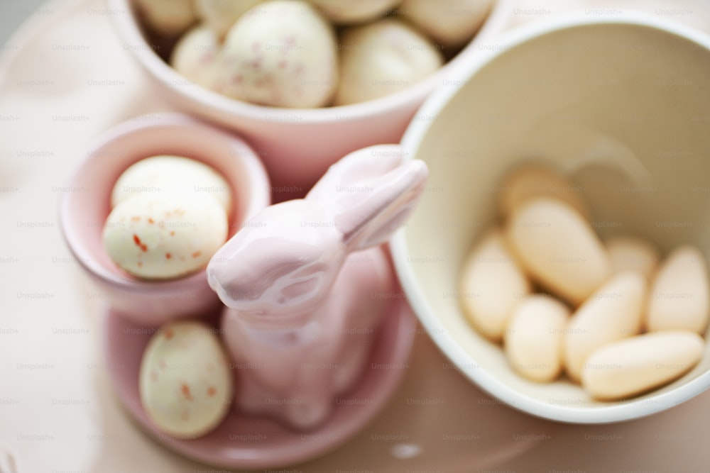 a pink plate topped with two bowls filled with eggs