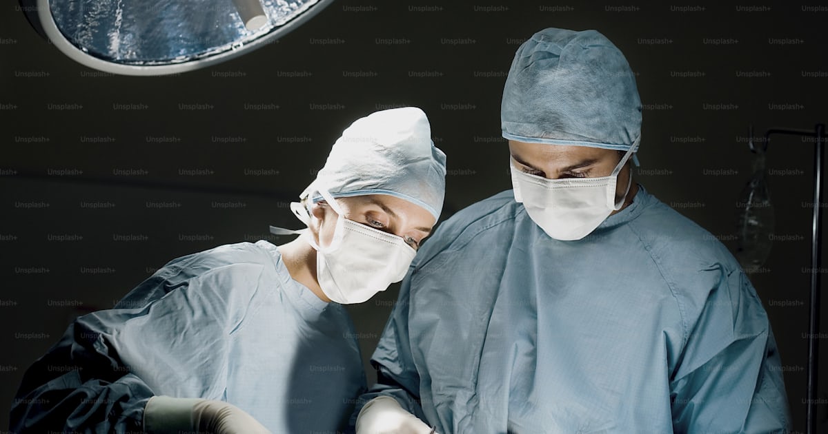 Dos cirujanos operando a un paciente en un quirófano foto – Imagen de ...