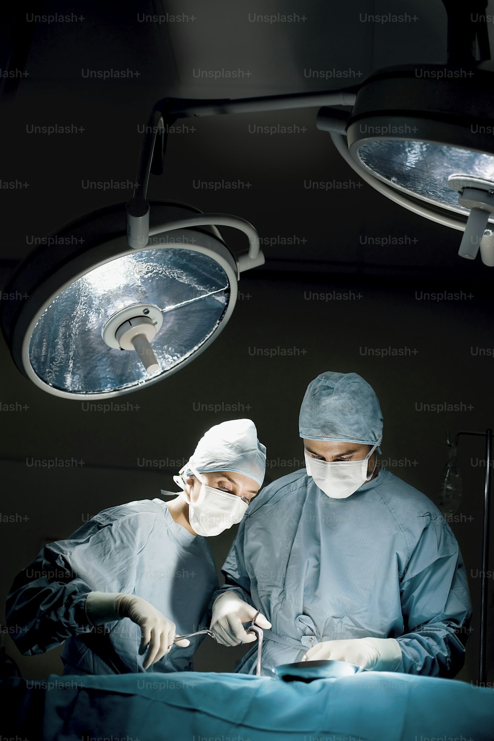 two surgeons operating on a patient in a operating room