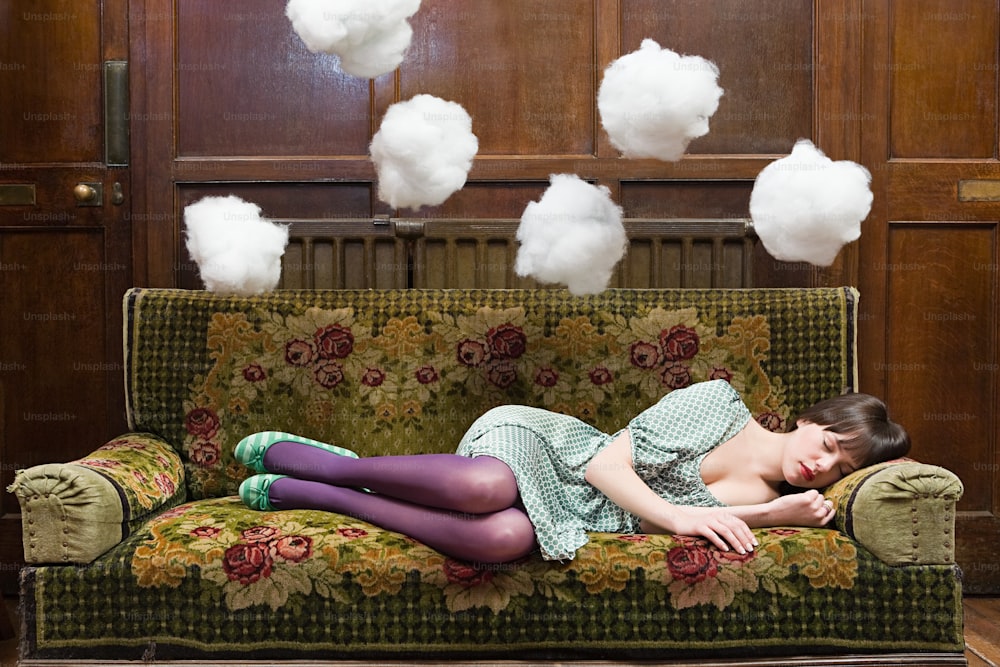a woman laying on top of a green couch