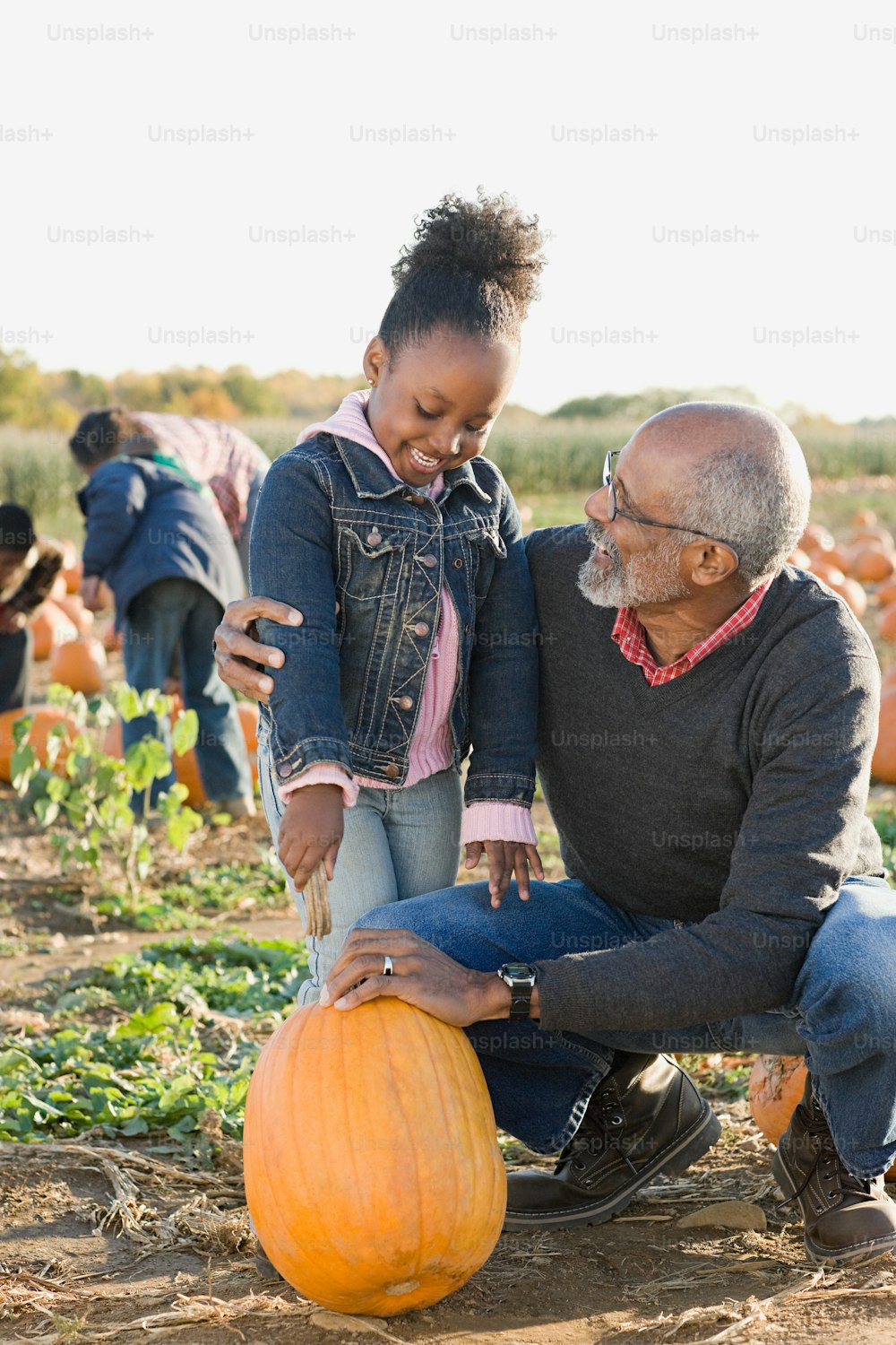a man and a little girl are in a pumpkin patch