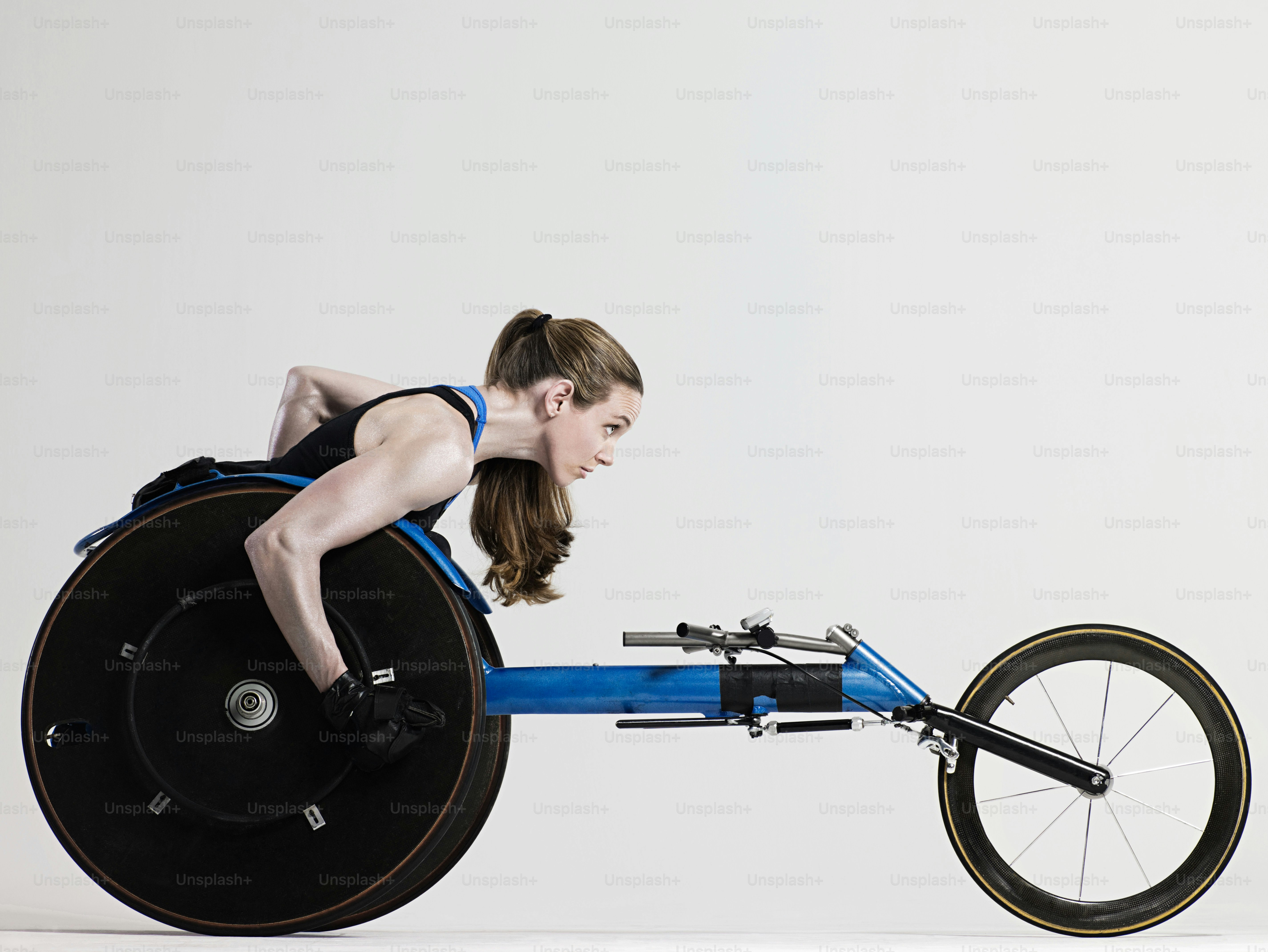 A woman in a black tank top riding a blue bike photo – Sports race ...