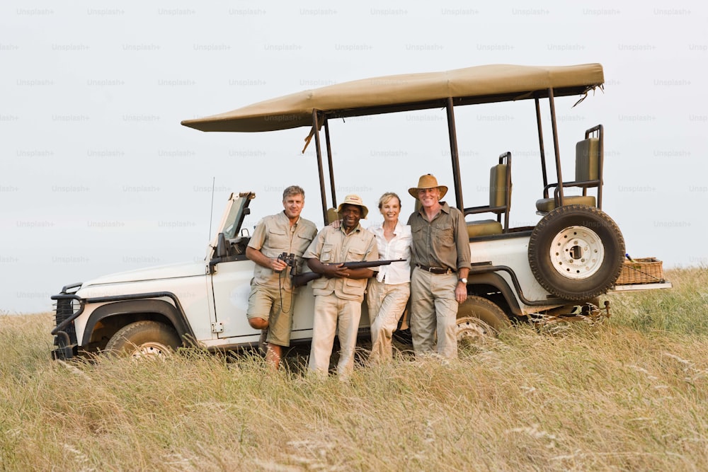 Un gruppo di persone in piedi davanti a un veicolo safari