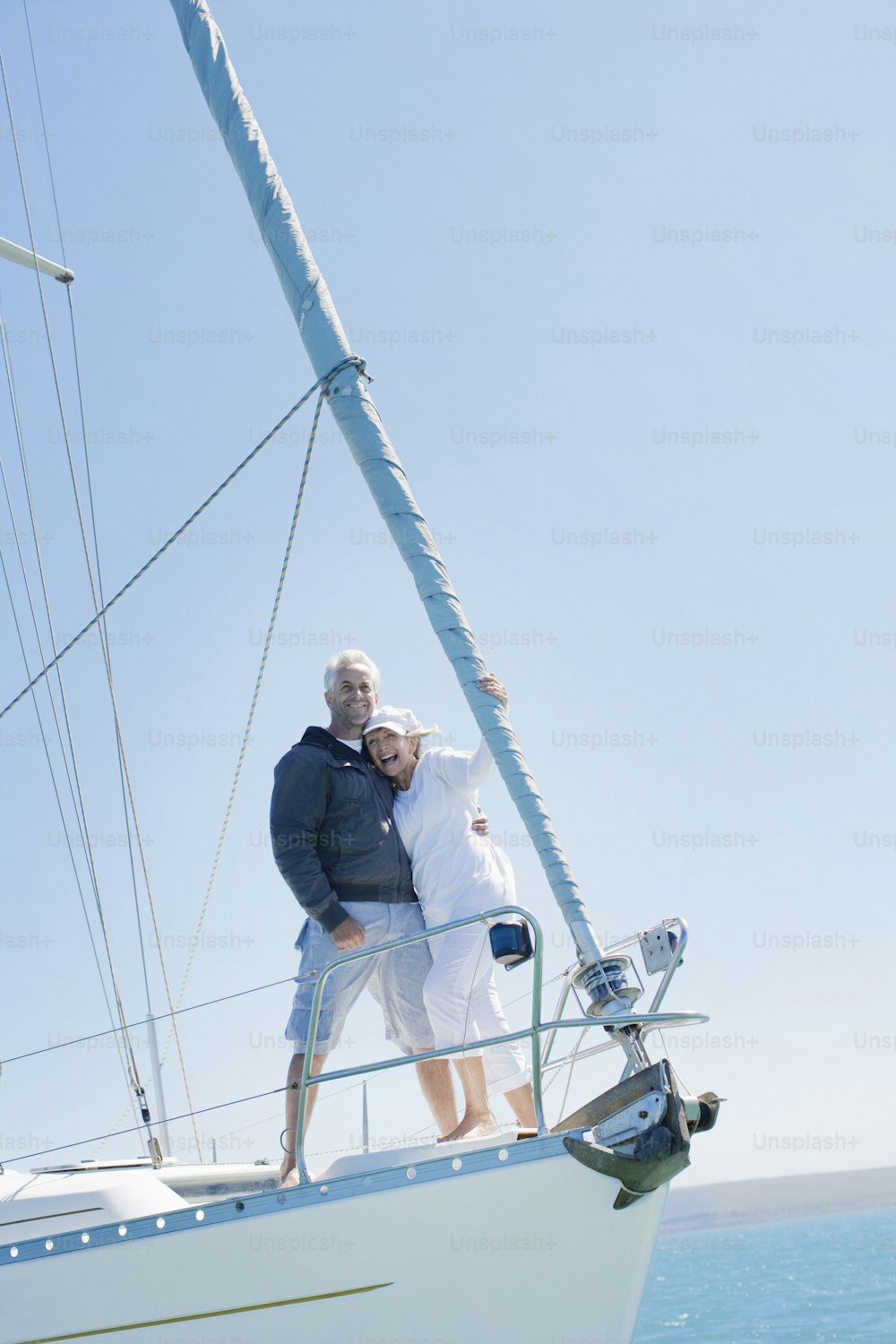 a man and a woman standing on a sailboat