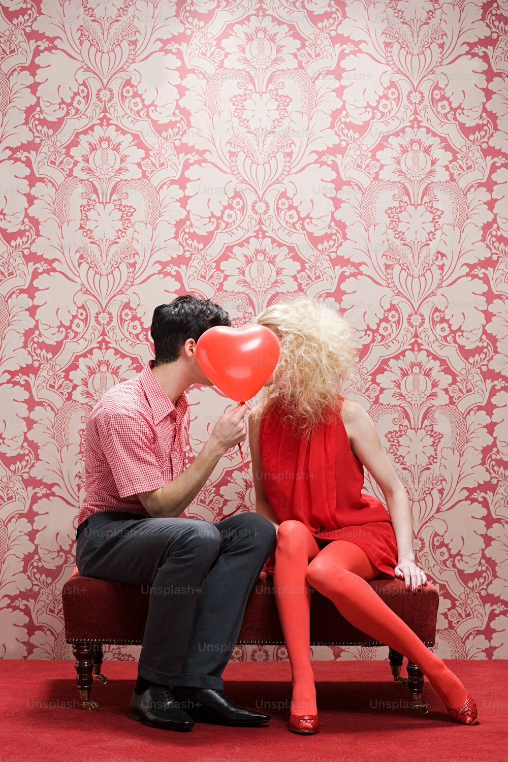 um homem e uma mulher sentados em um banco se beijando