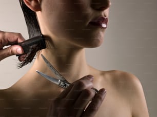 a woman is cutting her hair with a pair of scissors