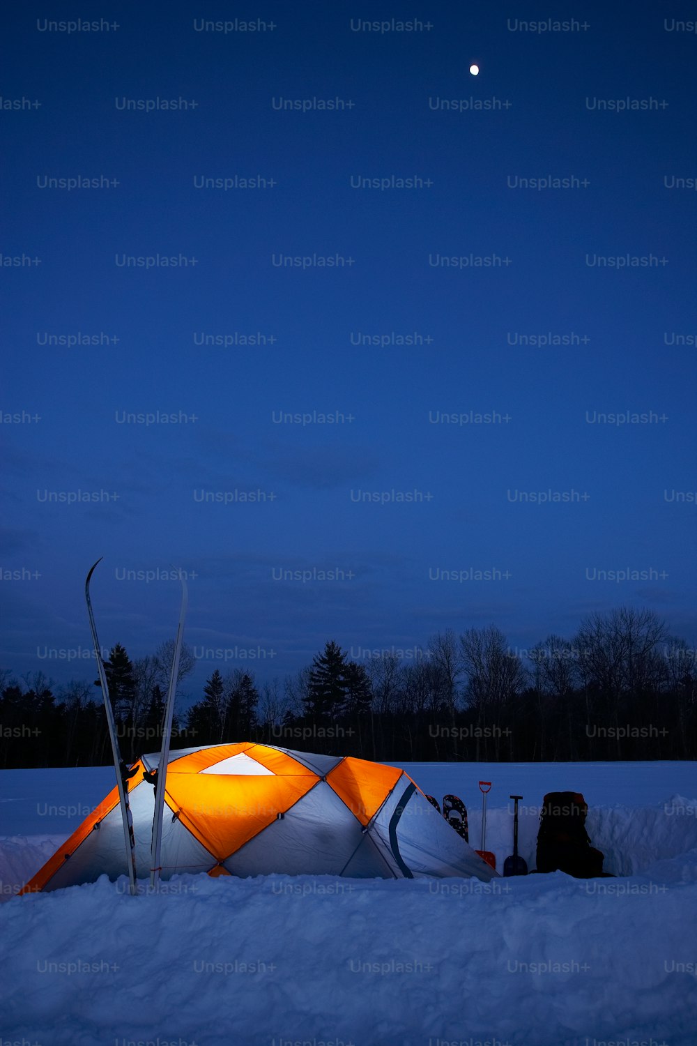 a tent is set up in the snow at night