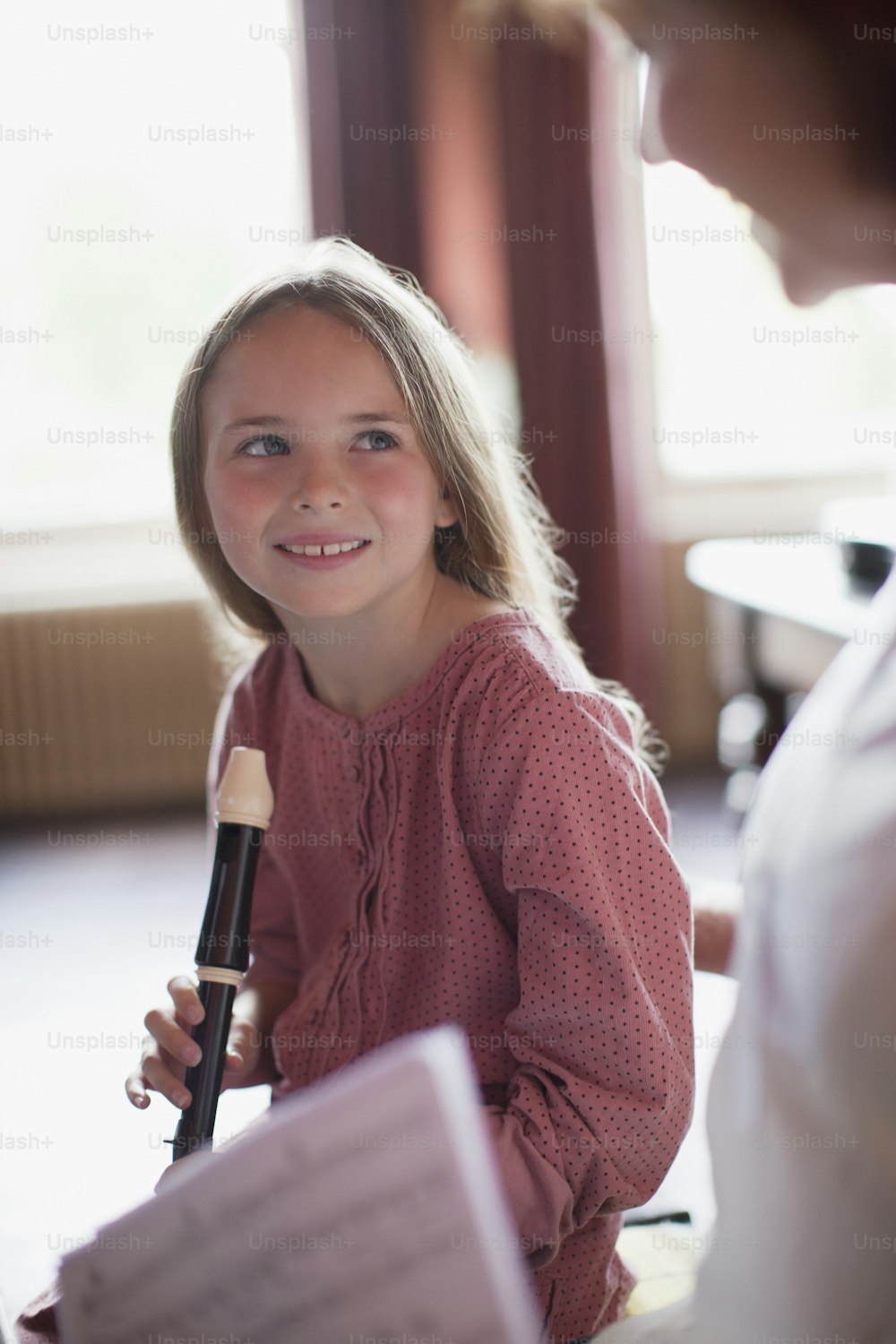 Una niña sostiene un micrófono y sonríe