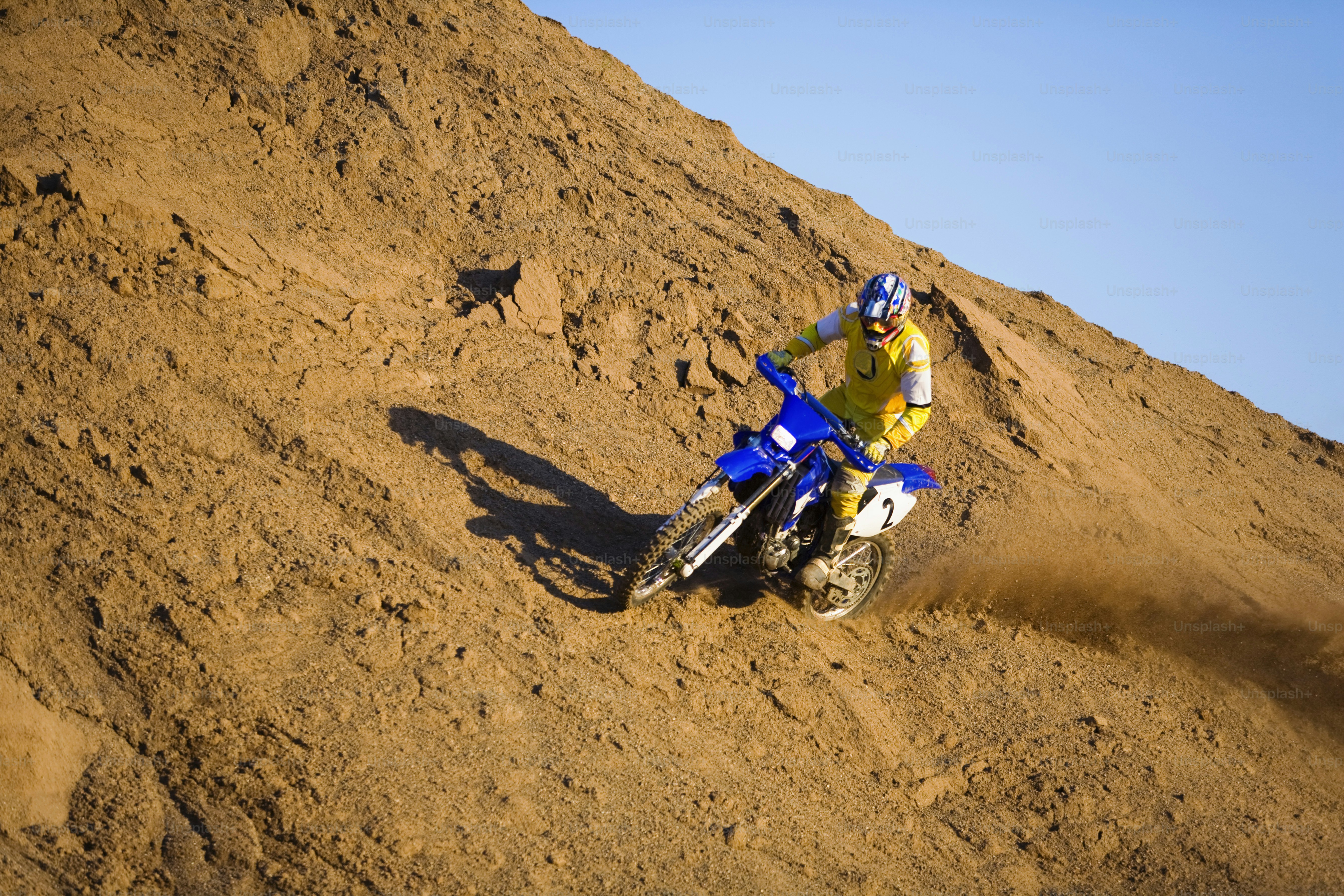 a man riding a dirt bike on top of a dirt hill