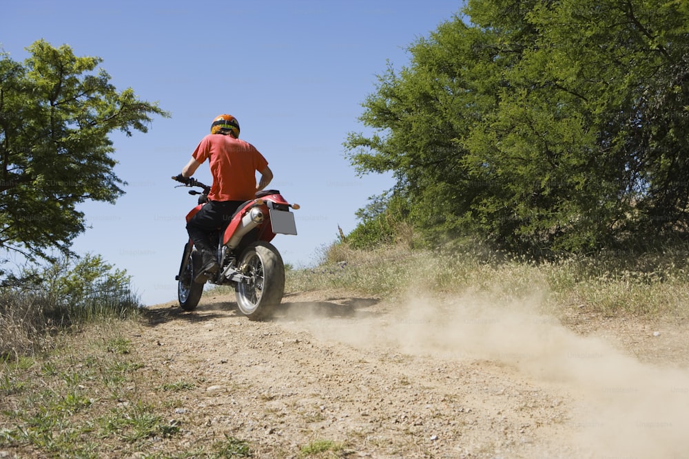 a man riding a dirt bike on a dirt road