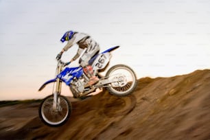 a man riding a dirt bike up the side of a hill