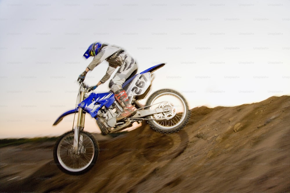 a man riding a dirt bike up the side of a hill